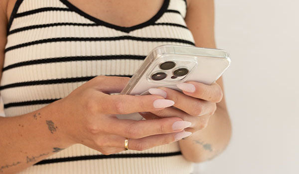 Person holding a smartphone with a white background - photographed in Australia