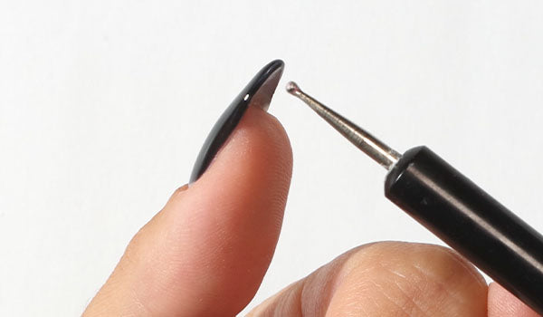 Pointing at a gel nails free edge - photographed in Australia on model